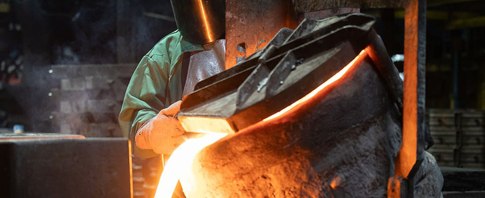 Foundry worker pouring molten iron Foundry worker pouring molten iron